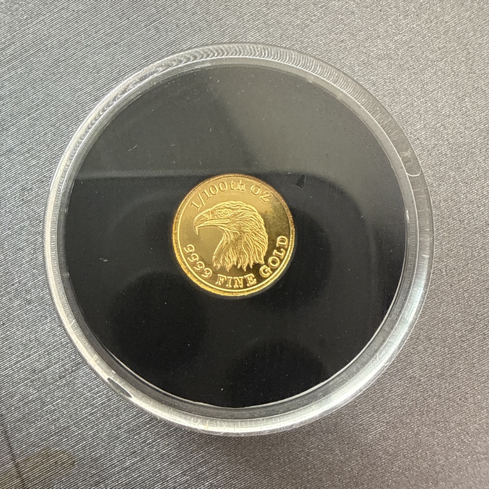 A 1/100 OZ MONARCH .9999 FINE GOLD EAGLE ROUND IN CAPSULE